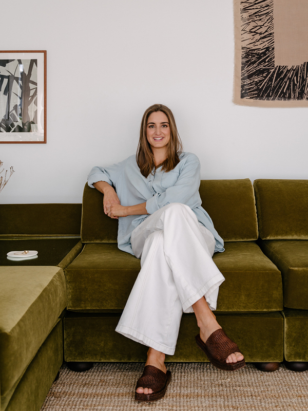 Reioni Douglas, founder of Culture Cush in Newcastle, sitting on a custom modular lounge she designed and handmade.