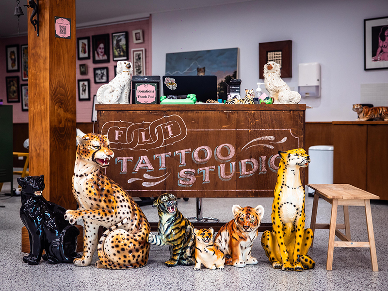 Reception area at FLT Tattoo Studio in Newcastle, featuring ceramic big cats and eclectic decor that reflect the studio’s playful, welcoming atmosphere.