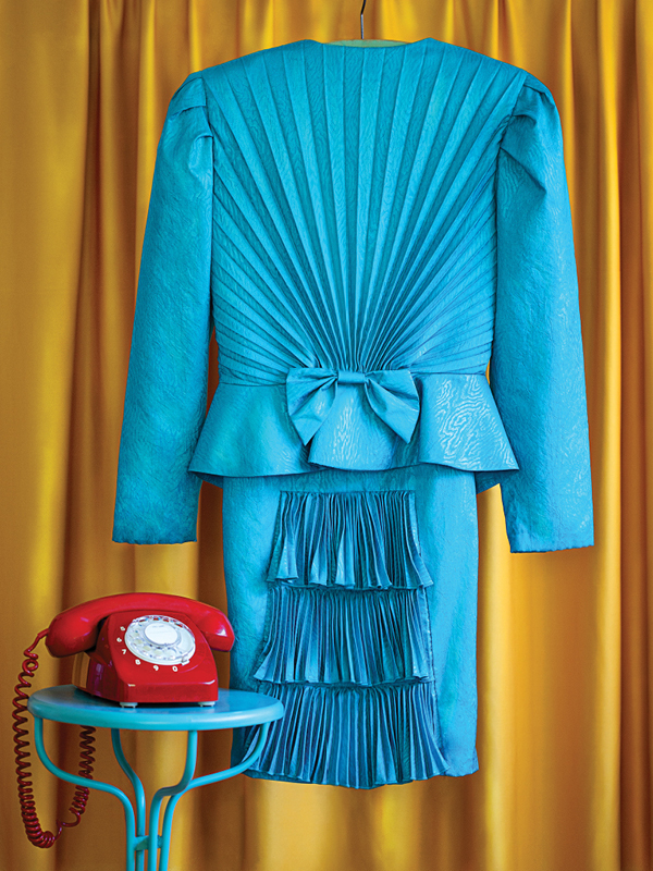 Pleated turquoise vintage dress with bow detail from The Retro Wardrobe Newcastle, styled with red phone and yellow curtain.