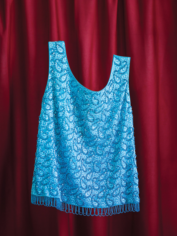 Turquoise sequinned vintage top from The Retro Wardrobe Newcastle, photographed on red fabric.